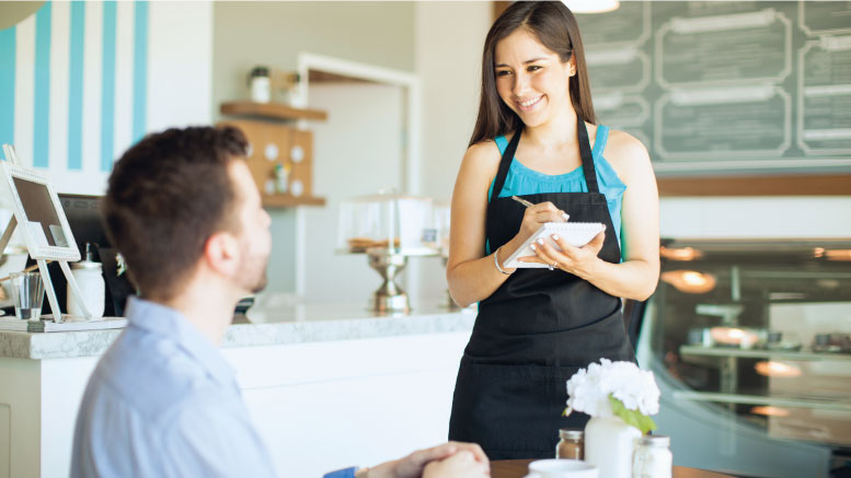 A waitress happily taking orders from a customer