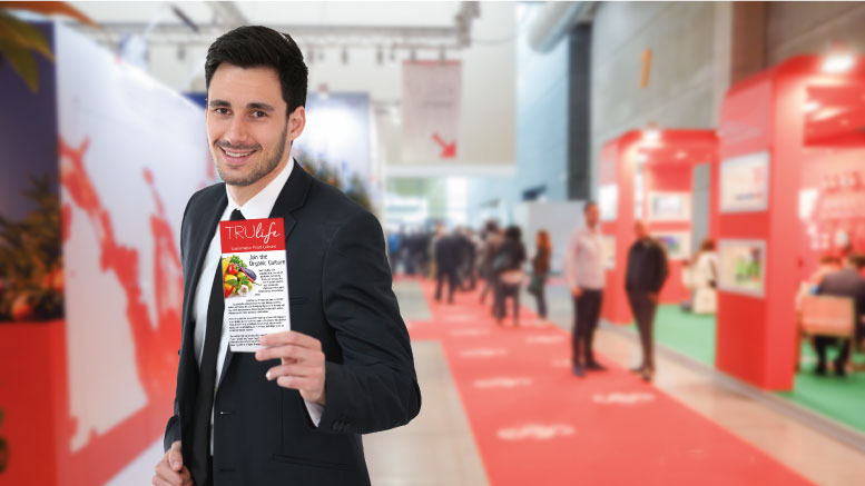 Booth presenter handing a brochure