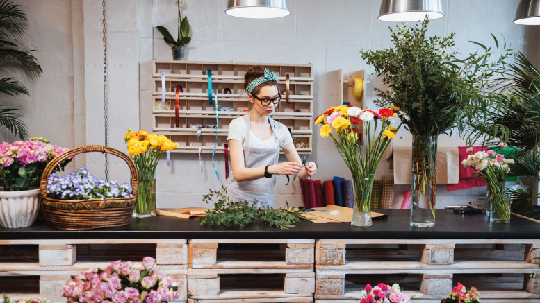 Flower shop employee arranging flowers